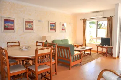 a living room with a table and a dining room at Vista Golfe in Quarteira