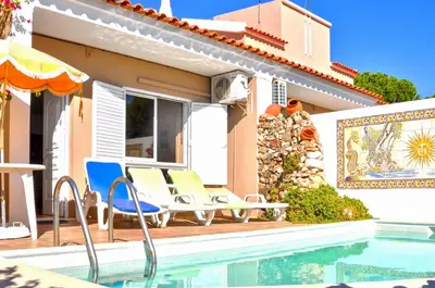 a house with chairs and a swimming pool at Vista Golfe in Quarteira