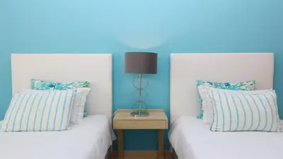 two beds in a room with blue walls at Aquamar 15 - Clever Details in Vilamoura