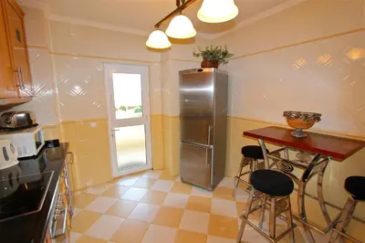 a kitchen with a stainless steel refrigerator and a table at Antelius 82 - Clever Details in Vilamoura