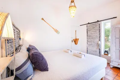 a bedroom with a large bed and a window at Casa do Cacto in Olhos de Água