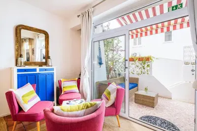 a living room with pink chairs and a sliding glass door at Casa do Cacto in Olhos de Água
