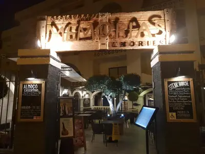 an entrance to a restaurant at night with a sign at Alta Oura in Albufeira