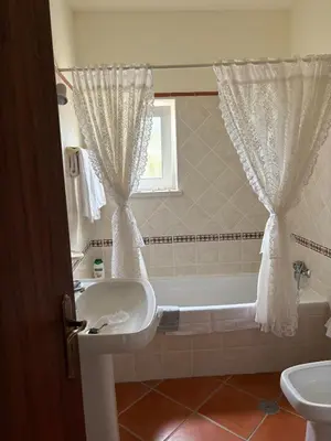a bathroom with a tub and a sink and a bath tub at Casa Oasis - Paraiso na Terra in Tunes