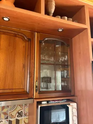 a kitchen with wooden cabinets and a microwave at Casa Oasis - Paraiso na Terra in Tunes