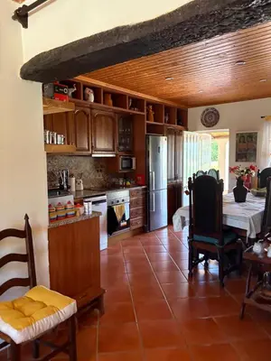 a kitchen with a dining table and a kitchen with at Casa Oasis - Paraiso na Terra in Tunes