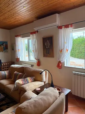 a living room with two couches and a table at Casa Oasis - Paraiso na Terra in Tunes