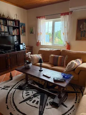 a living room with a couch and a coffee table at Casa Oasis - Paraiso na Terra in Tunes
