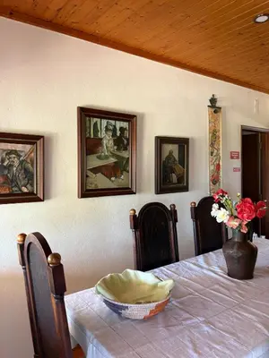 a dining room with a table with a vase of flowers at Casa Oasis - Paraiso na Terra in Tunes