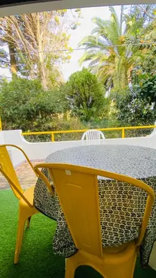 a yellow table and chairs on a patio at Apartamento a 5 min a pé da praia, com terraço grande ao sol, no Rés-Chão in Quarteira