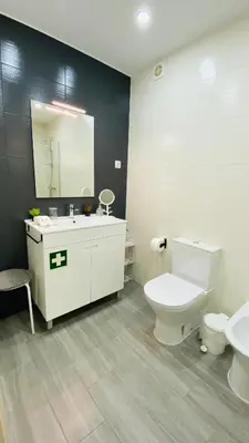 a bathroom with a sink and a toilet and a mirror at Apartamento a 5 min a pé da praia, com terraço grande ao sol, no Rés-Chão in Quarteira