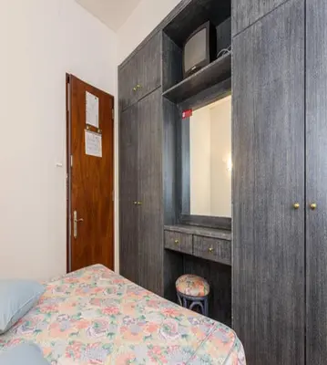 a bedroom with a bed and a dresser and a mirror at Residencial Miramar in Quarteira