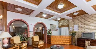 a lobby with chairs and a tv in a building at Residencial Miramar in Quarteira