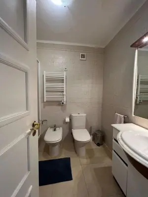 a white bathroom with a toilet and a sink at Apartamento Perfect Holidays in Albufeira