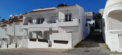 a white building with a fence next to it at Brisamar Villas OCEANS in Albufeira