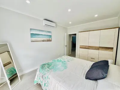 a bedroom with a bed and a painting on the wall at Brisamar Villas OCEANS in Albufeira