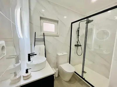 a bathroom with a shower and a toilet and a sink at Brisamar Villas OCEANS in Albufeira
