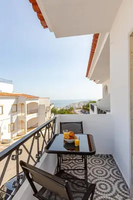 a balcony with a table with a meal on it at Brisamar Villas OCEANS in Albufeira