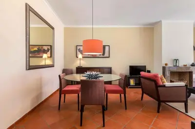 a living room with a table and chairs at 2 bedroom Vila Sol Golf Resort in Quarteira