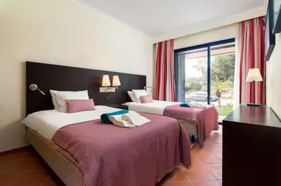 a hotel room with two beds and a window at 2 bedroom Vila Sol Golf Resort in Quarteira