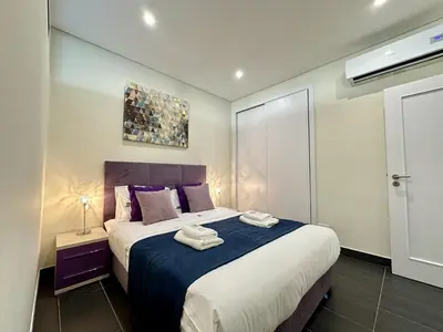 a bedroom with a large bed with towels on it at Quarteira Deluxe With Pool by Homing in Quarteira