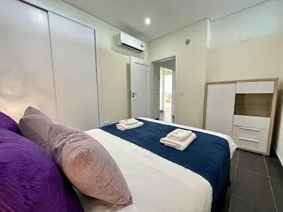 a bedroom with a large bed with towels on it at Quarteira Deluxe With Pool by Homing in Quarteira
