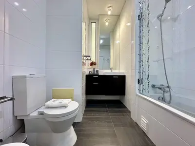 a white bathroom with a toilet and a shower at Quarteira Deluxe With Pool by Homing in Quarteira