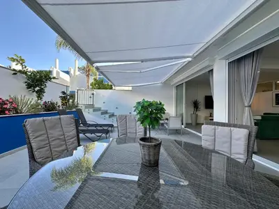 a patio with a glass table and chairs at Quarteira Deluxe With Pool by Homing in Quarteira