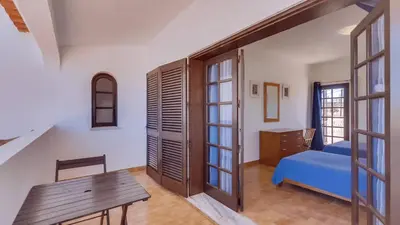 a bedroom with a blue bed and a wooden table at Villa Frederique by Gabi Miguel in Albufeira