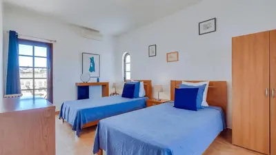 a bedroom with two beds with blue sheets at Villa Frederique by Gabi Miguel in Albufeira