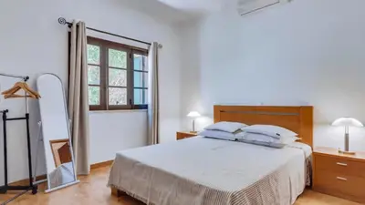 a white bedroom with a bed and a mirror at Villa Frederique by Gabi Miguel in Albufeira