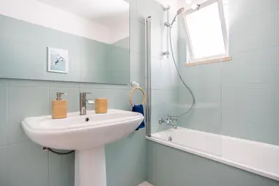a white bathroom with a sink and a shower at Stay in Old Town - 5 min walking to the beach in Albufeira
