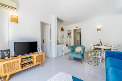 a living room with a tv and a blue couch at Stay in Old Town - 5 min walking to the beach in Albufeira