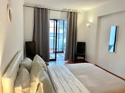 a bedroom with a bed and a sliding glass door at Casa Caki - A 15 minutos da praia in Albufeira
