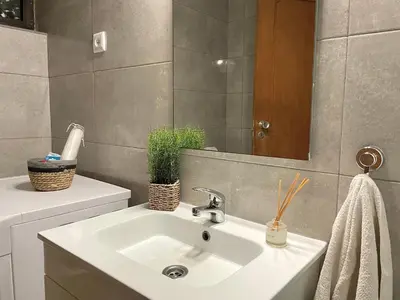 a bathroom with a sink and a mirror at Casa Caki - A 15 minutos da praia in Albufeira