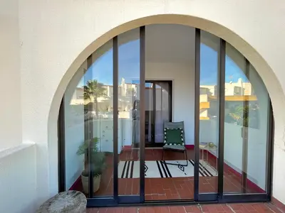 an arched glass door on a building with a patio at Casa Caki - A 15 minutos da praia in Albufeira