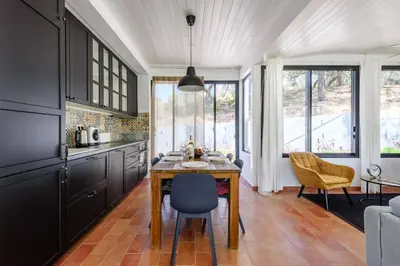 a kitchen with a table and chairs in a room at Casa da Calma, Vale do Lobo in Almancil