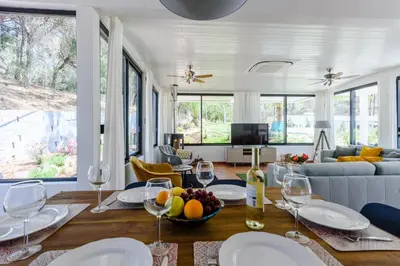 a living room with a table with wine glasses at Casa da Calma, Vale do Lobo in Almancil