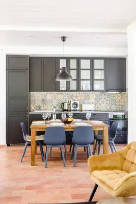 a kitchen with a wooden table and blue chairs at Casa da Calma, Vale do Lobo in Almancil