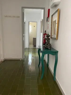 a hallway with a green table in a room at Villa Snoppy in Albufeira