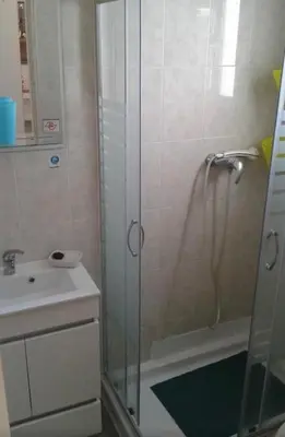 a bathroom with a glass shower and a sink at Villa Snoppy in Albufeira