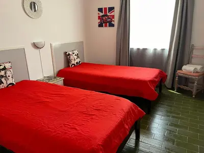 two beds in a room with red sheets at Villa Snoppy in Albufeira