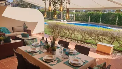 a table and chairs in a patio with a swimming pool at Vilamoura Paradisus Laguna with Patio and Pool in Quarteira