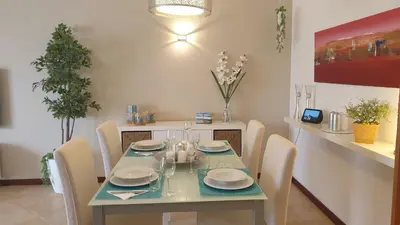 a dining room with a green table and chairs at Vilamoura Paradisus Laguna with Patio and Pool in Quarteira