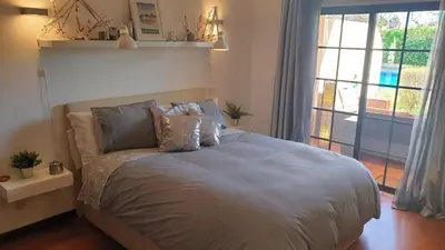 a bed in a bedroom with a large window at Vilamoura Paradisus Laguna with Patio and Pool in Quarteira