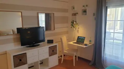 a room with a desk with a television and a laptop at Vilamoura Paradisus Laguna with Patio and Pool in Quarteira