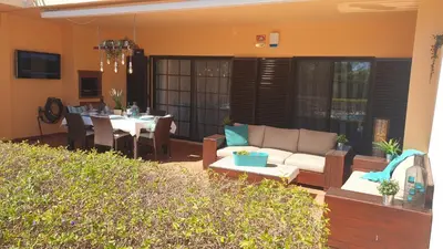 a patio with a couch and a table and a dining room at Vilamoura Paradisus Laguna with Patio and Pool in Quarteira