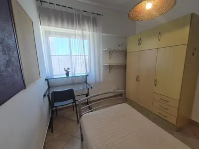 a bedroom with a bed and a desk and a window at Casa da Baixa in Faro