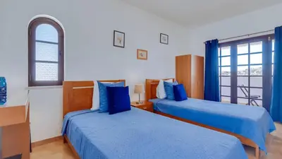 a hotel room with two beds and a window at Villa Frederique in Albufeira