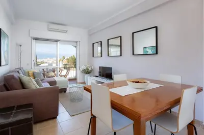 a dining room with a table and a living room at ELI FLAT just few steps from the Strip in Albufeira in Albufeira